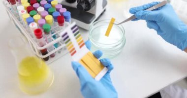 Eller, laboratuvar ortamında şeritler ve reaktörler kullanan kimyasal bir test yürütüyor.