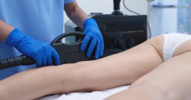 Nitelikli bir profesyonel, hastaların bacak bölgelerine zararsız bir kozmetik prosedür uyguluyor.