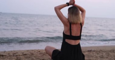 Huzurlu bir an, deniz kenarında huzur içinde meditasyon yapan bir kadını yakalıyor. Huzur ve sükuneti kucaklıyor.