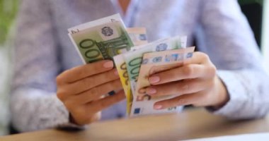 Düzenli olarak Euro banknotlarını sayan bir kişi, mali planlama ve işlemlerin odak noktasında olduğunu yansıtır