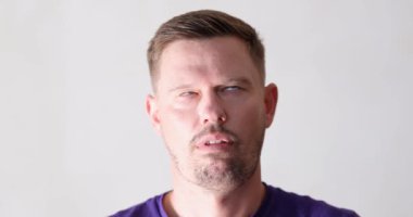 Kısa saçlı, ciddi görünümlü bir adam güçlü kararlılığını ve odaklanmasını vurgulayarak kendine güveniyor.