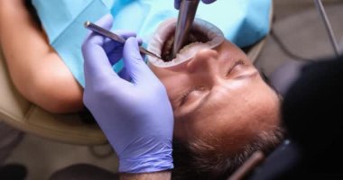 Bir hasta klinikte dişçi muayenesi yaptırıyor. Yetenekli bir dişçi ve dişçi aletleri.