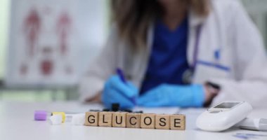 Kendini adamış bir sağlık çalışanı yakınlardaki masada bulunan çeşitli laboratuvar ekipmanlarıyla glikoz testi yapıyor.