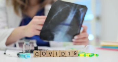 Yetenekli bir sağlık uzmanı COVID19 Xray 'i çeşitli tıbbi malzemelerle birlikte inceliyor.