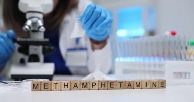 Bir bilim adamı laboratuvarda metamfetamin analiz ediyor, uyuşturucu araştırmaları ve temel güvenlik protokollerine odaklanıyor.