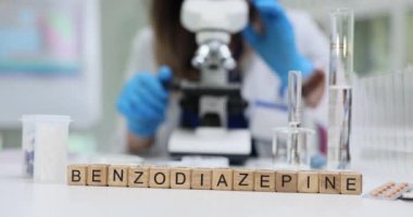 Laboratuvar ortamında, kendini adamış bir bilim adamı özenle bir mikroskop kullanarak benzodiazepin bileşiklerini inceliyor.