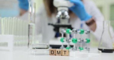 Bir laboratuvar ortamında, bir bilim adamı analiz için mikroskop kullanırken DMT üzerinde süresiz araştırma yapar.