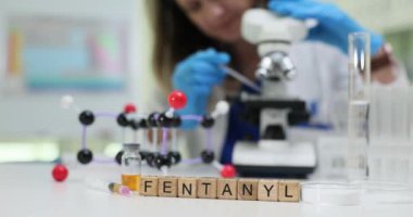 Mikroskopi ile birlikte moleküler modelleri içeren kapsamlı fentanil araştırmalarını gösteren bir laboratuvar sahnesi var.