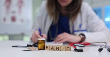 Yoğun bir ofiste, kendini işine adamış bir sağlık çalışanı panik ve aciliyeti sembolize eden öğeler arasında not alır.