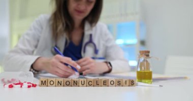 Bir sağlık uzmanı, hasta bakımına odaklanmış klinik bir ortamda laboratuvar materyalleriyle mononükleoz inceler.