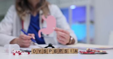 Bir sağlık uzmanı hazımsızlığı tartışır. Görseller kullanır ve hastaların netlik için etkileşimlerini teşvik eder.