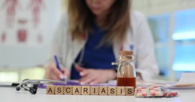 Bir sağlık uzmanı, tüm masaya yayılmış çeşitli ilaçlarla asariyaz üzerine çalışmalar yapmaktadır.