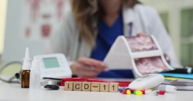 Yetenekli bir tıp uzmanı gerekli sağlık araçlarıyla birlikte ICD11 belgelerini özenle inceliyor