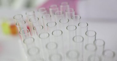 Pembe eldivenli laboratuvar teknisyeni özel raflarda boş test tüpleri düzenliyor. Steril araştırma ortamında bilimsel araştırma