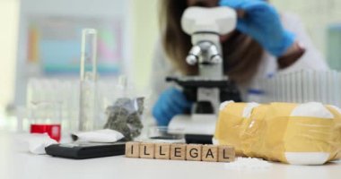 Laboratuvar ortamında, bir bilim adamı güçlü bir mikroskop altında çeşitli yasadışı maddeleri titizlikle inceliyor.