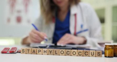 Bir sağlık çalışanı Staphylococcus 'u bir laboratuvarda inceleyerek patojenler üzerine önemli tıbbi araştırmaları vurguluyor.