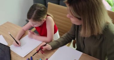 Anne, basit matematik problemini çözmek için kızına adımlarını açıklıyor. Kadınlar, kızların sayma ve toplamanın temellerini anlamalarına yardımcı olur. Yavaş çekim