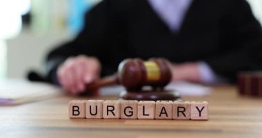 Profesyonel yargıç tokmağı vurdu ve hırsızlıktan suçlu bulundu. Minyatür ahşap bloklar masanın üzerinde kelime cümbüşü oluşturur. Yavaş çekim
