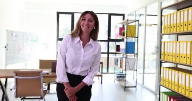 Profesyonel kadın sekreter, müşteriyi sıcak bir gülümsemeyle karşılıyor. Gülümseyen kadın ofis çalışanı müşteriyi belirlenen toplantı odasına götürüyor.