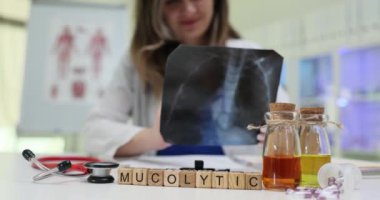 Tıbbi bir ortamda, bir sağlık uzmanı röntgeni dikkatlice inceler ve mukolitik tedavileri değerlendirir.