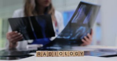 Bir sağlık uzmanı, radyoloji ortamındaki röntgen görüntülerini özenle inceleyerek, hayati teşhisleri vurguluyor.