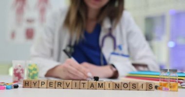 Kendini adamış bir sağlık çalışanı, görsel araçlar ve temel tıbbi gereçleri kullanırken hipervitaminozu inceliyor.