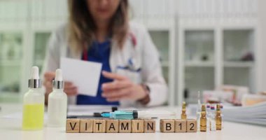 Çalışan doktora karşı şırınga ve şişelerle B12 vitamini yaz. Kadın sıhhiyeci, refah için ilave reçete yazan test sonuçlarını inceliyor