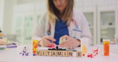 E vitamini ve dağınık ilaç kapsülleri yazar doktorlara karşı. Kadın sıhhiyeci, modern sağlık hizmetlerinde sağlık için reçete yazar