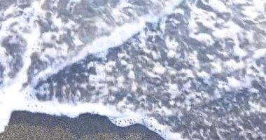 Yumuşak okyanus dalgaları yaz aylarında ıslak kumsalda yazılan sözcükleri siliyor. Zamanda ağır çekim acımasız ve kaçınılmaz geçiş kavramı