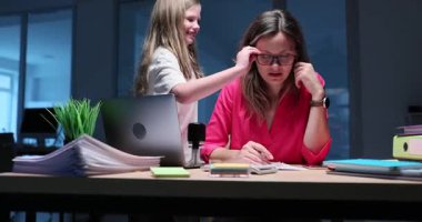 Oyuncu küçük kız, çalışan annesini rahatsız etmek için gece vakti bardak çalıyor. Kızı, kadınlardan evrak işlerini bırakıp, evlerine gitmelerini istiyor.