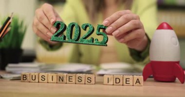 İş kadını, 2025 yılı için yenilikçi İş Fikri sunuyor. Kadın ofis çalışanı mali görünüm ve beklenen büyümeyi tartışıyor. Yavaş çekim