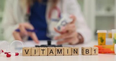 Kadın doktor hastaya B1 vitamini için reçete yazıyor. Doktor yorgunluk ve zayıflık belirtilerini gidermek için B1 vitamini yazar. Yavaş çekim