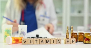 Kadın doktor kan dolaşımını iyileştirmek için PP vitamini öneriyor. Beslenme uzmanı hastaya önerilen dozda PP vitamini yazar. Yavaş çekim