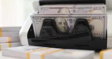 Para sayma makinesi 100 dolarlık banknotları topluyor. Banka yavaş çekimde ilave banknot paketi ile hassas bankacılık teknolojisi