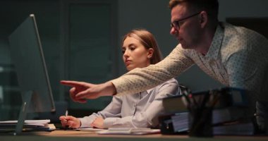 Becerikli iş adamı bilgisayardaki stajyerlerin çalışmalarını analiz eder. Adam finansal hesaplamaların doğruluğunu artırmak için önerilerde bulunuyor. Yavaş çekim