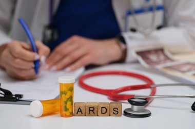 Bir tıbbi uzman, ARDS 'ın anahtar bilgilerini steteskopla ve etkin hasta bakımı için yakındaki ilaçlarla belgeleyecek.