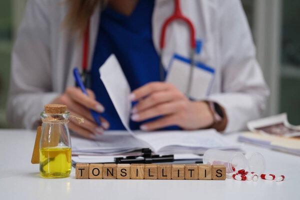 Квалифицированный врач тщательно изучает различные медицинские документы с особым упором на тонзиллит и его средства