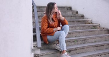 Sabırsız kadın merdivenlerde oturur ve kol saatine bakar. Hüsrana uğramış dişi tanışıklığı bekler ve zamanı kontrol etmek için saate bakar. Yavaş çekim