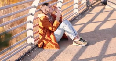 Sıkıntılı kadın sonbahar kenti köprüsünün soğuk betonunda tek başına oturuyor. Hüsrana uğramış dişi çaresizlik içinde dua ederken el ele tutuşur. Yavaş çekim