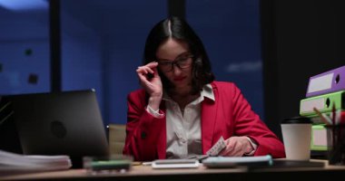 Kadın ofis çalışanı bardakları ayarlar ve dolar sayar. İş kadını geceleri ofiste masa başında oturur ve nakit para sayar. Yavaş çekim