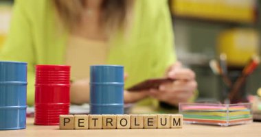Kelime PETROLEUM iş tartışmasının özünü sembolize eder. İş kadını, petrol tedarik anlaşmasının detaylarını gözden geçiriyor. Yavaş çekim