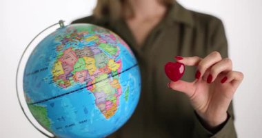 Bu resim aşkı ve küresel farkındalığı sembolize ediyor, bu temaları iletmek için kalple birleştirilmiş bir küreyi gösteriyor.