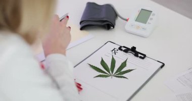 Eğitimli bir uzman, tıbbi esrar yapraklarını yakından inceleyerek, hayati sağlık eğilimlerini ve ilerlemeleri vurgular
