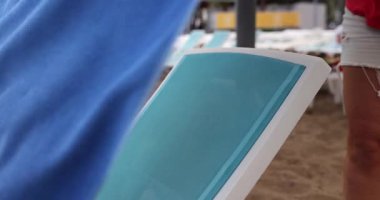 Renkli havluları ve güneşlenen güneşli havluları tasvir eden huzurlu ve sakin bir sahil sahnesi.