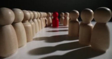 Çarpıcı kırmızı bir figür, gerçek benzersizliği temsil eden ahşap bir çember içinde tek başına duruyor.