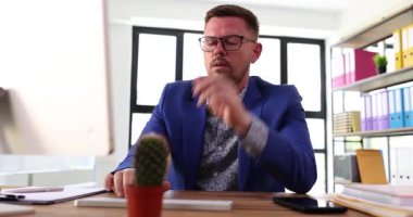 Renkli klasörleri ve ilham veren büyüleyici kaktüsü olan modern bir ofiste kendini işine adamış bir profesyonel.