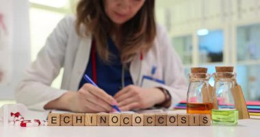 Kendini adamış bir sağlık uzmanı şişelerle dolu bir laboratuvarda Echinococcosis üzerinde çalışıyor ve güvenlik etiketlerini temizliyor.