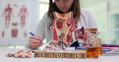 Bir öğrenci anatomi eğitimi ve sağlık bilincinin önemini vurgulayan bir rektosel modeli üzerinde çalışmaktadır.