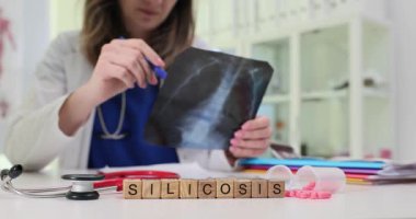 Klinik bir ortamda, bir sağlık uzmanı silikoz hastalığını gösteren bir röntgeni dikkatle inceler.