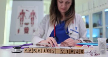 Bir tıp uzmanı modern bir laboratuvar ortamında Marburg Virüsü ile ilgili örnekleri inceliyor..